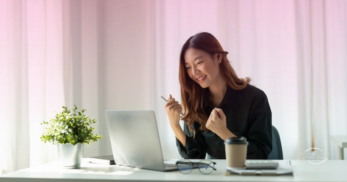 Smiling woman working on laptop with coffee