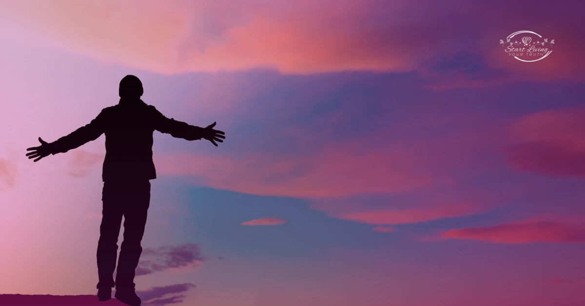 Silhouette of person embracing vibrant sunset sky.