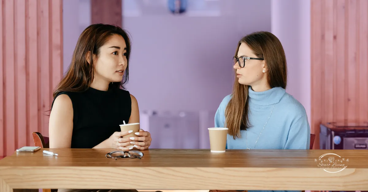 Women talking over coffee at a table.