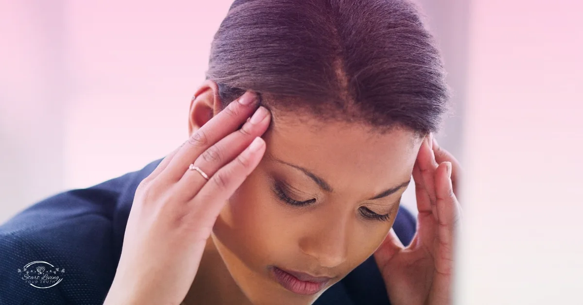 Person experiencing headache, pressing temples with hands.