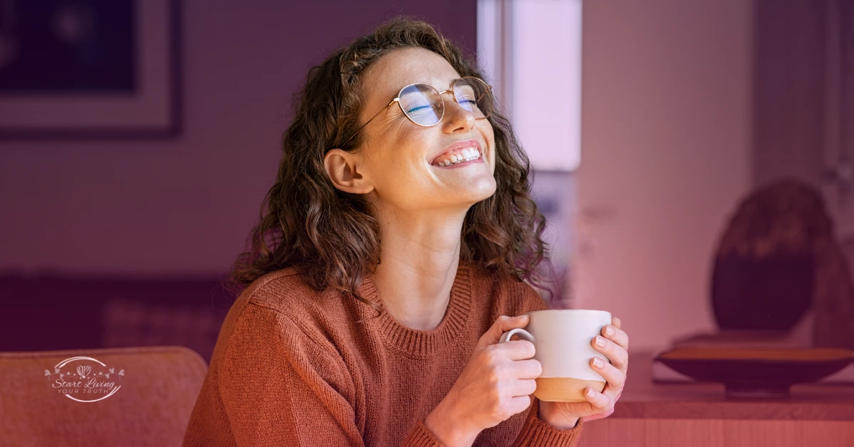 Smiling person holding a coffee cup indoors.