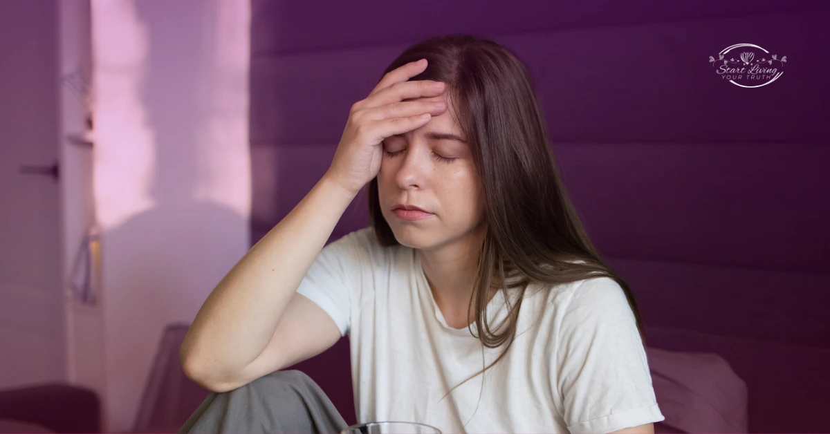 Woman experiencing headache and fatigue indoors.