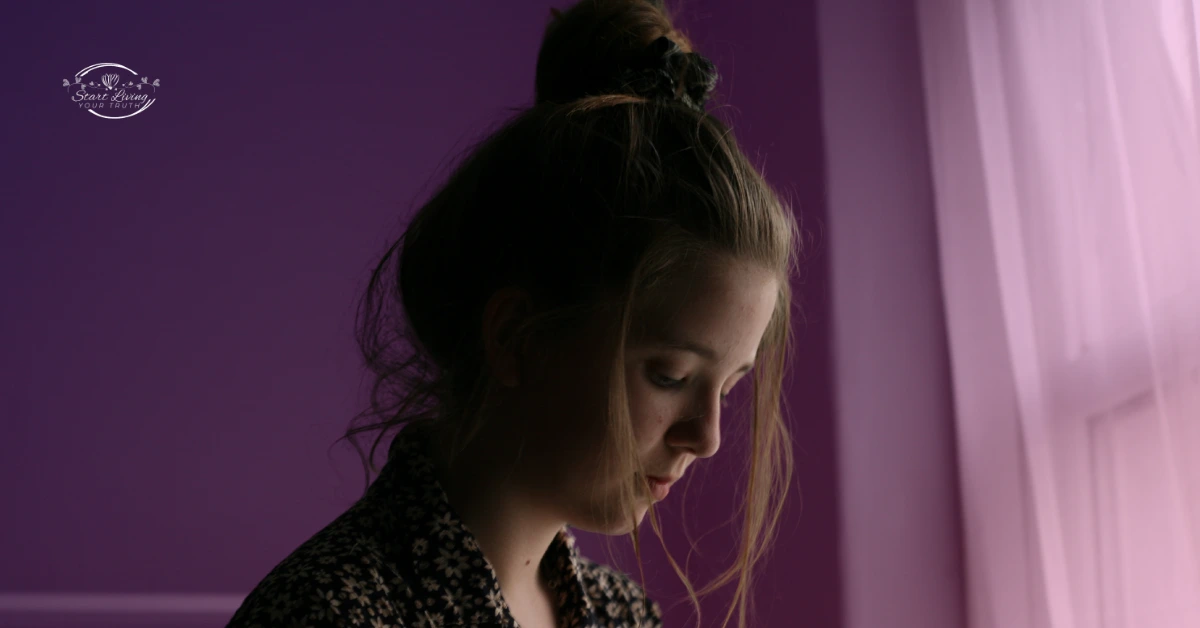 Silhouette of woman in profile against purple background.
