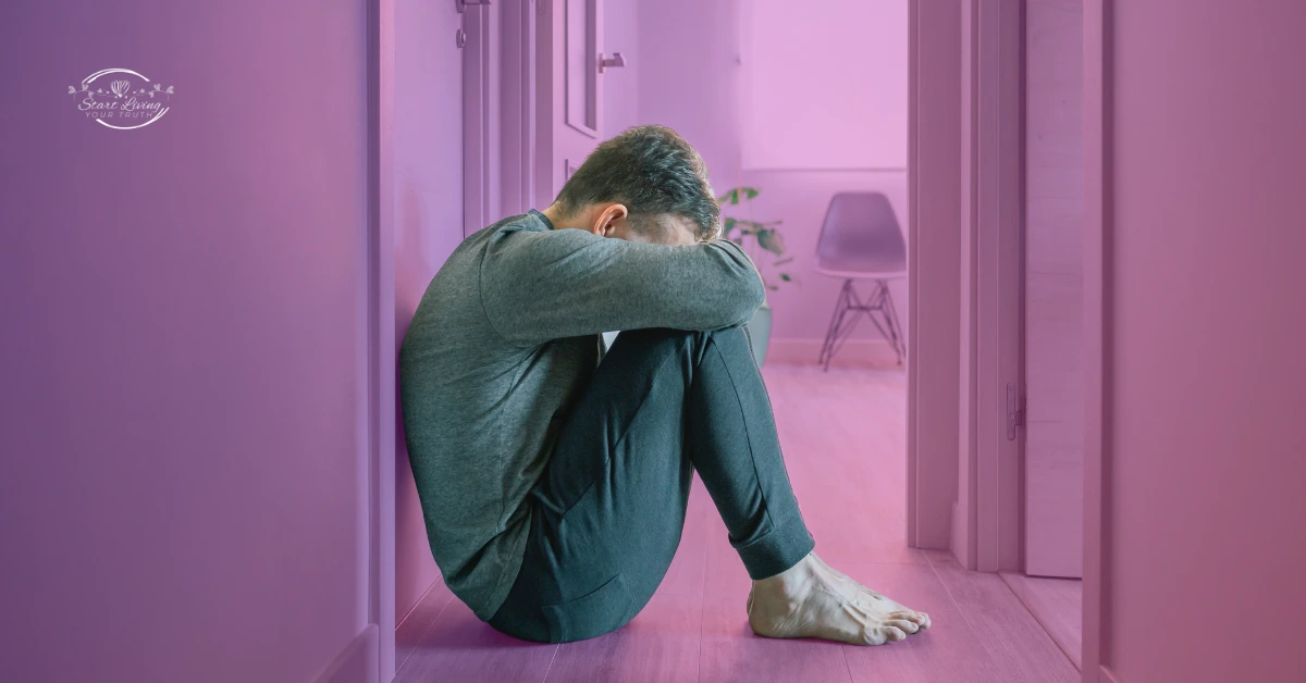Person sitting in hallway, looking distressed.